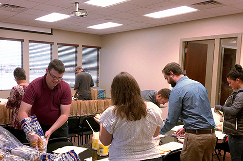 Veracity employees assembling sack lunches for The Road Home